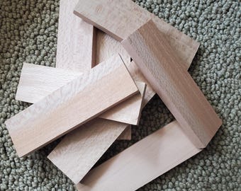 May include: A stack of six light brown wooden blanks, likely for crafting or woodworking projects. The blanks are rectangular and have a smooth, polished surface.