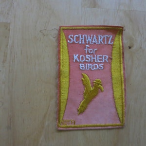 May include: Embroidered patch with the text "SCHWARTZ for KOSHER BIRDS" in white lettering. The patch has a pink background with a yellow border and a yellow bird graphic.