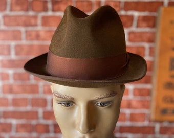 May include: A brown fedora hat with a brown ribbon band. The hat is on a mannequin's head.