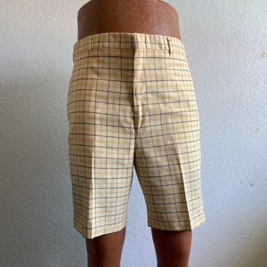 May include: Beige and brown plaid shorts with a straight leg.