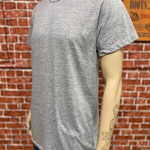 May include: A heather grey short-sleeved t-shirt with a crew neck.
