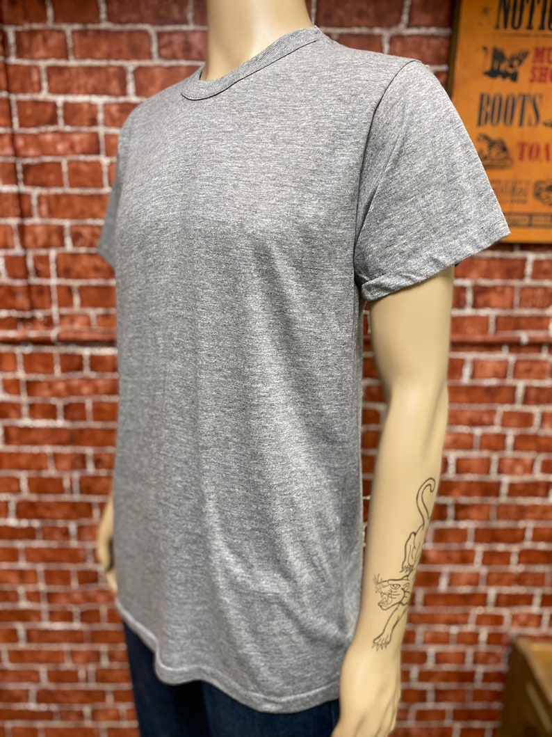 May include: A heather grey short-sleeved t-shirt with a crew neck.