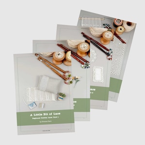 May include: A set of four books titled "A Little Bit of Lace" with a green cover and white text. The books are about beginner bobbin lace unit 1 by Evonne Carr. The books are stacked on top of each other and show examples of lacework.