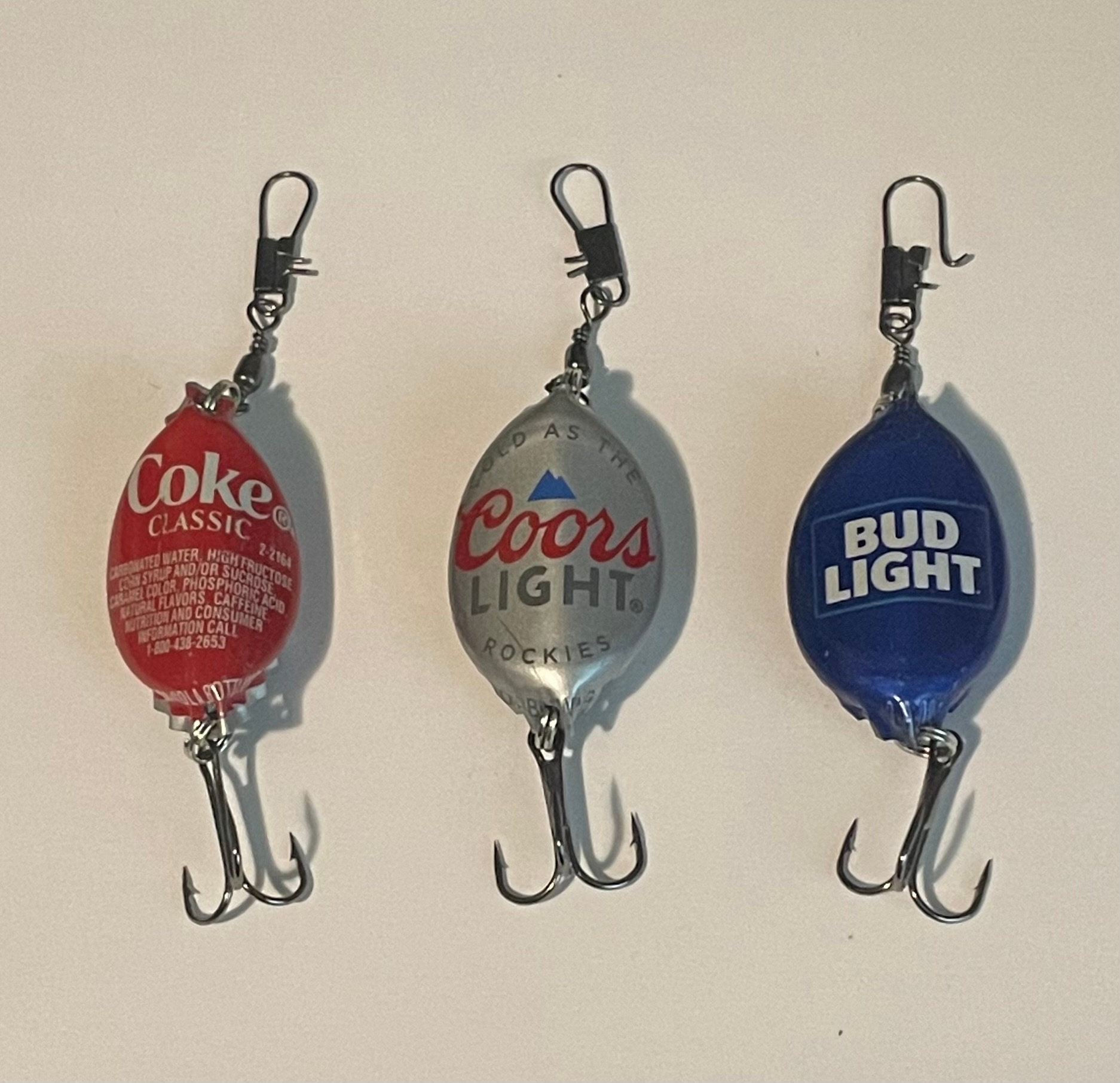 One Bud Light, one Coke, and one Coors Light bottle cap fishing lures