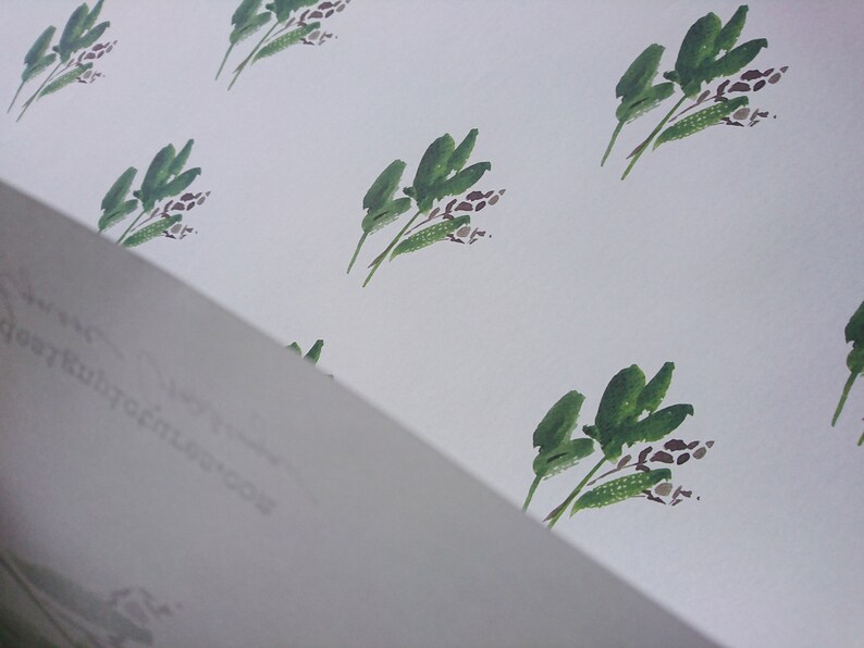 May include: A white background with a repeating pattern of green leafy branches with brown flower buds.