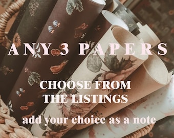 Puede incluir: Una cesta de mimbre contiene varios papeles enrollados con diseños florales y botánicos. Los papeles son en tonos marrón, verde y crema. El texto en la imagen dice: "ANY 3 PAPERS, CHOOSE FROM THE LISTINGS, add your choice as a note."