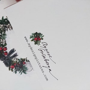May include: A white card with a black and green wreath with red berries and a black bird. The text "Annexe  Art  Gallery" and "www.mydesignpictures.com" is printed on the card.