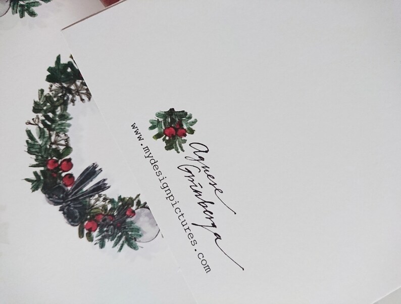 May include: A white card with a black and green wreath with red berries and a black bird. The text "Annexe  Art  Gallery" and "www.mydesignpictures.com" is printed on the card.