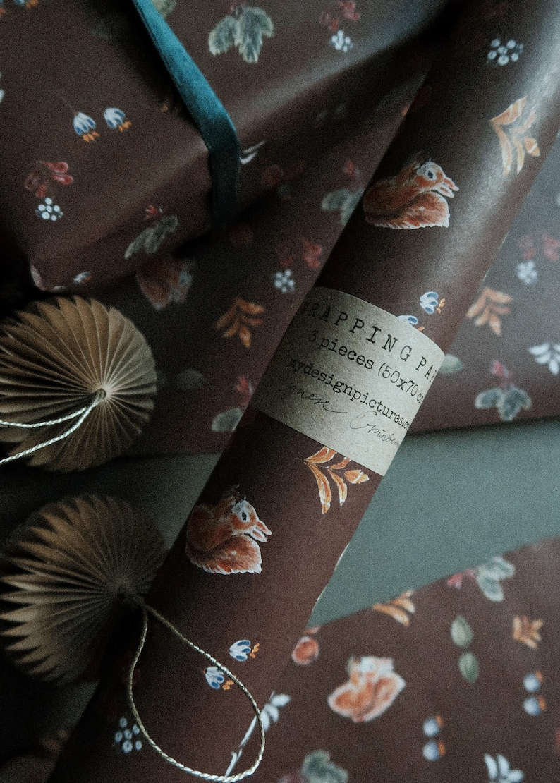 May include: A roll of brown wrapping paper with a squirrel and floral pattern. The paper is labeled "Wrapping Paper 3 pieces (50x70 cm) by designpictures.com".