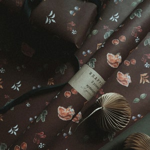 May include: A roll of brown wrapping paper with a squirrel and leaf pattern. The paper is labeled "WRAPPIN 3 pieces mydesign" and is partially unrolled. A brown paper fan is on top of the paper.