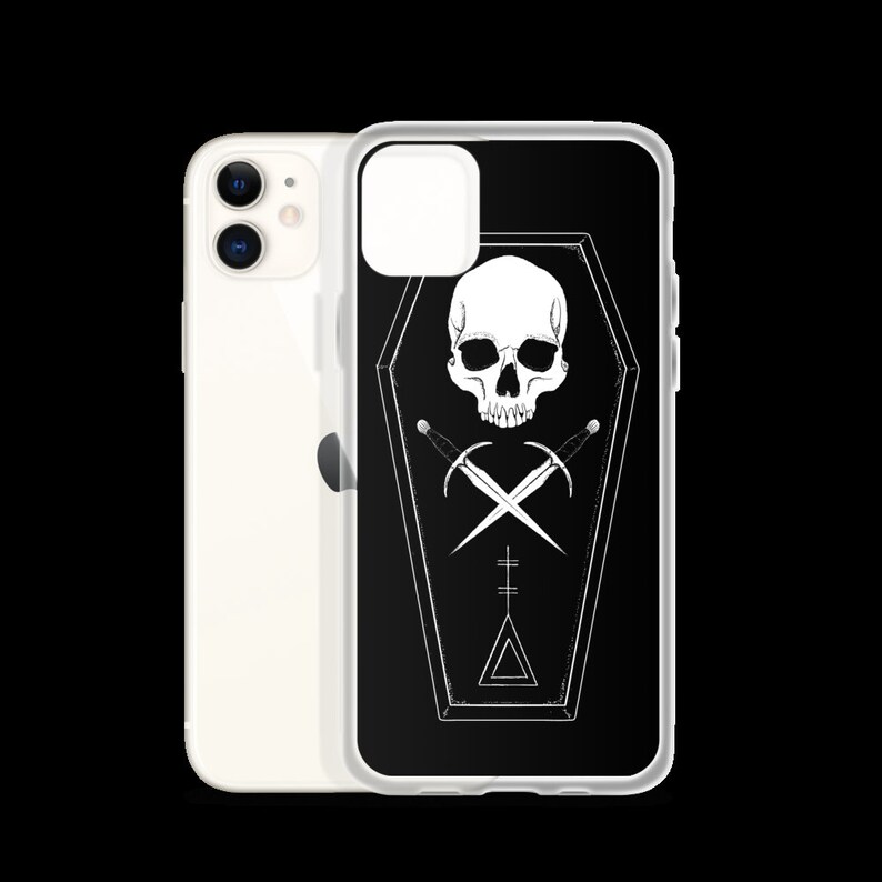 Puede incluir: Una funda de iPhone negra con un dise&ntilde;o de calavera y huesos cruzados blancos dentro de un ata&uacute;d. El dise&ntilde;o est&aacute; sobre un fondo negro con un contorno blanco.