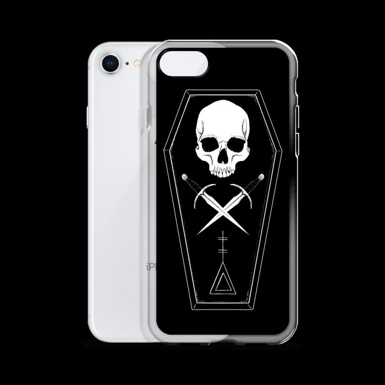 Puede incluir: Carcasa de tel&eacute;fono negra con un dise&ntilde;o blanco de calavera y huesos cruzados dentro de una forma de ata&uacute;d. El dise&ntilde;o tambi&eacute;n incluye un tri&aacute;ngulo y una l&iacute;nea vertical.