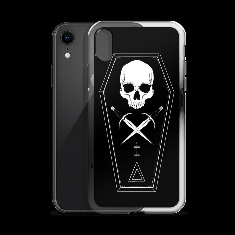 Puede incluir: Una funda de tel&eacute;fono negra y blanca con un dise&ntilde;o de calavera y huesos cruzados dentro de un ata&uacute;d. El dise&ntilde;o est&aacute; sobre un fondo negro con un contorno blanco.