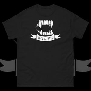 May include: Black t-shirt featuring a white graphic of a set of fangs and the text "Bite Me".