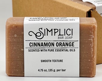 May include: A brown bar soap with a white label that reads "LONG LASTING BAR SOAP CINNAMON SCENTED WITH PURE ESSENTIAL OILS SIMPLICI BAR SOAP CINNAMON ORANGE SCENTED WITH PURE ESSENTIAL OILS SMOOTH TEXTURE 4.75 oz, 135 g. per bar"