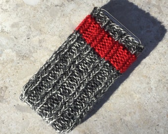 Puede incluir: Una funda de teléfono de punto gris y blanco con una franja roja en el medio.