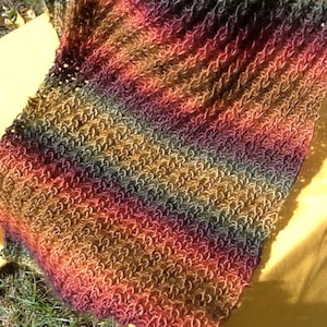 May include: A multi-colored knitted scarf with a striped pattern in shades of brown, red, orange, and green.