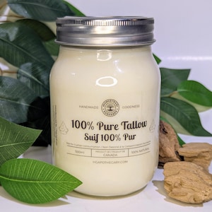 May include: A jar of 100% Pure Tallow with a silver lid, set amongst green leaves and wood pieces. The jar features a white label with the text "HANDMADE GOODNESS" and "100% Pure Tallow Suif 100% Pur". The jar contains 500ml of product.