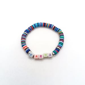 May include: A colourful beaded bracelet with the word "KARMA" spelled out in white letter beads.