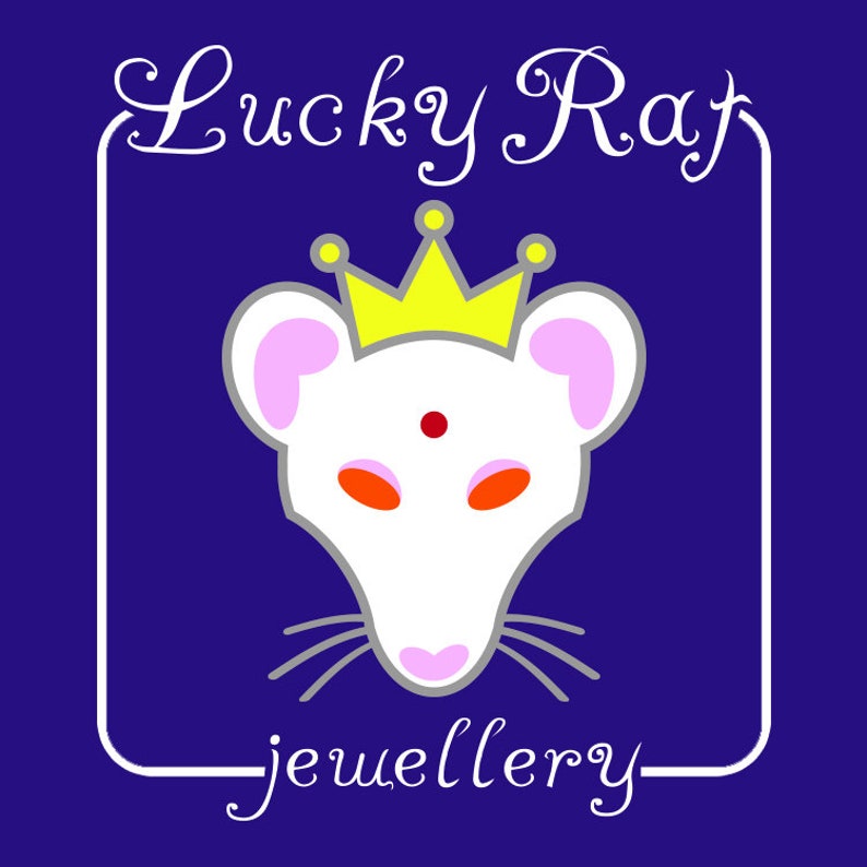 Op de afbeelding: Een grafisch logo op een donkerblauwe achtergrond met een witte rattenkop met roze oren, oranje ogen en een rode stip op het voorhoofd. De rat draagt een gele kroon met kleine gele cirkels. De tekst Lucky Rat jewellery is in het wit.