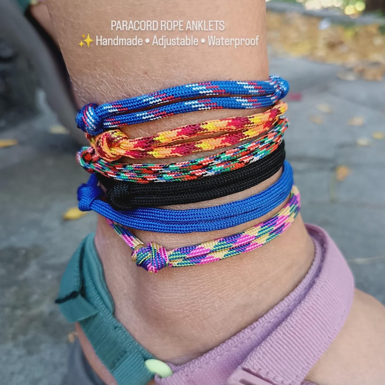 May include: A stack of five paracord rope anklets featuring various patterns and colors, including blue, yellow-orange, multicolored, solid black, and pink-blue. The text PARACORD ROPE ANKLETS Handmade Adjustable Waterproof is visible above the anklets.