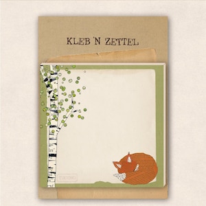 Könnte beinhalten: Ein grüner und weißer Notizblock mit einer Fuchs-Illustration und dem Text "Kleb 'n Zettel" auf der Vorderseite.