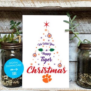 Op de afbeelding: Witte kerstkaart met een boomontwerp gemaakt van sterren, ornamenten en tekst. De kaart leest "We Wish You a Happy Tiger Christmas" in rood en paars. Een oranje pootafdruk staat onderaan.