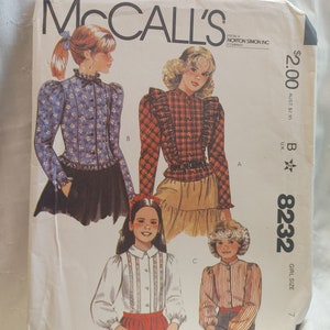 May include: A sewing pattern for blouses, McCall's pattern number 8232, size 7. The pattern includes four different styles of blouses with ruffled collars and long sleeves. The pattern is printed on white paper with black text and illustrations.