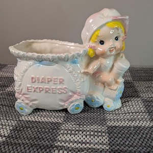 Peut inclure: Ensemble de trois mugs en céramique avec une finition mate et mouchetée. Les tasses sont dans les tons crème, gris clair et gris foncé. Chaque mug a un design simple et minimaliste, idéal pour le café ou le thé.