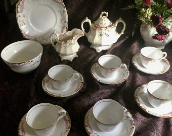 Early china tea set with rose tone and gilded notes.  Set of six cups and saucers with serving pieces