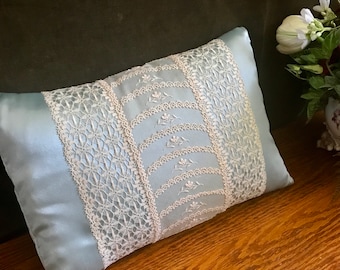 Vintage lace hand sewn to new aqua poly charmeuse pillow.