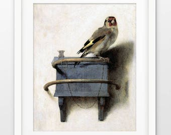 Puede incluir: Una pintura de un jilguero posado en una pequeña caja azul con un marco de metal dorado. El pájaro está mirando al espectador con la cabeza ligeramente inclinada hacia un lado. El fondo es de color beige claro.