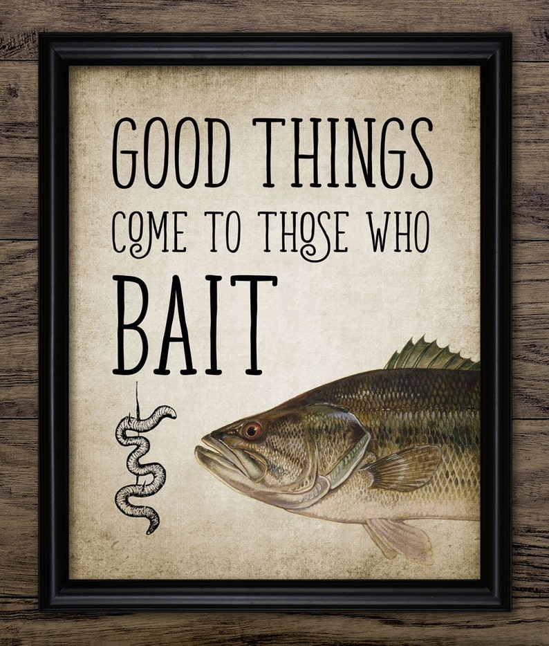 May include: A vintage-style print with a black frame and a beige background. The print features a black and white illustration of a worm on a hook and a largemouth bass with the text "Good things come to those who bait."