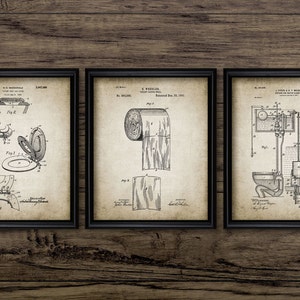 May include: Three vintage patent drawings in black and white, framed in black frames. The drawings depict a toilet seat, a roll of toilet paper, and a toilet flushing mechanism.
