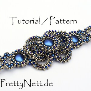 Może przedstawiać: Bransoletka z koralik&oacute;w w srebrno-niebieskiej kolorystyce. Bransoletka charakteryzuje się powtarzającym się wzorem małych koralik&oacute;w i większych, okrągłych, niebieskich koralik&oacute;w. Bransoletka wykonana jest z r&oacute;żnych koralik&oacute;w, w tym koralik&oacute;w nasiennych, koralik&oacute;w bugle i koralik&oacute;w okrągłych. Bransoletka jest pięknym i skomplikowanym elementem biżuterii.