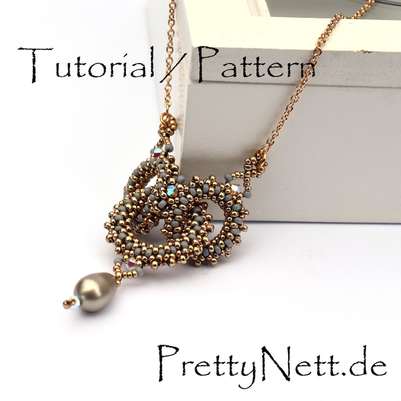 Może przedstawiać: Naszyjnik z szarych i złotych koralik&oacute;w z wisiorem w kształcie łzy. Naszyjnik leży na białym tle z tekstem "Tutorial/Pattern" i "PrettyNett.de".