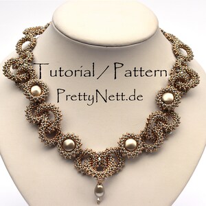 Może przedstawiać: Delikatny naszyjnik z koralik&oacute;w w kolorze złotym i szarym z perłowym wisiorem. Naszyjnik charakteryzuje się powtarzającym się wzorem splecionych k&oacute;ł i koralik&oacute;w w kształcie kwiat&oacute;w. W obrazie widoczny jest tekst "Tutorial/Pattern PrettyNett.de".
