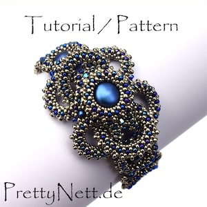 Może przedstawiać: Bransoletka z koralik&oacute;w srebrnych i niebieskich z dużym niebieskim kamieniem szlachetnym w środku. Bransoletka jest wykonana z małych koralik&oacute;w nasiennych i ma delikatny, skomplikowany wz&oacute;r. Bransoletka jest oznaczona jako "Tutorial/Wz&oacute;r" i "PrettyNette.de".