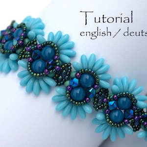 K&ouml;nnte beinhalten: Ein t&uuml;rkisfarbenes und blaugr&uuml;nes Armband mit Blumenmuster. Das Armband ist aus kleinen Perlen und gr&ouml;&szlig;eren runden Perlen gefertigt. Die Perlen sind in einem Blumenmuster mit einem Zentrum aus blaugr&uuml;nen Perlen angeordnet.