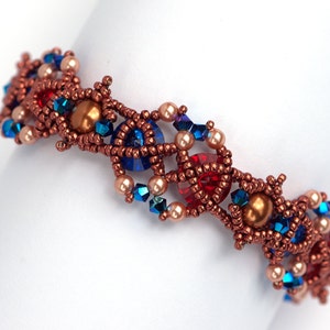 May include: A copper-toned beaded bracelet with a geometric design. The bracelet features red, blue, and cream-coloured beads.