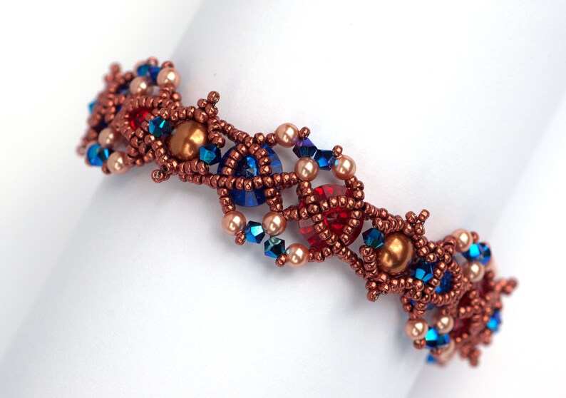 May include: A copper-toned beaded bracelet with a geometric design. The bracelet features red, blue, and cream-coloured beads.