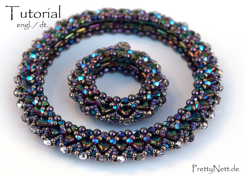 May include: Two iridescent beaded necklaces, one larger than the other, with a purple, blue, and green color scheme. The necklaces are made of small, faceted beads and are arranged in a spiral pattern.