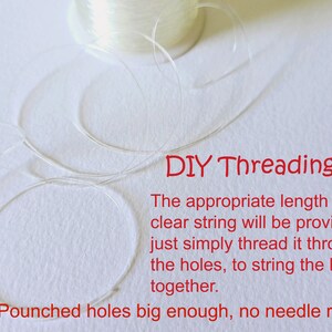 May include: A spool of clear string with a length of string already unwound. The text "DIY Threading" is written in red. The text below reads "The appropriate length of clear string will be provided, just simply thread it through the holes, to string the letters together. Pounched holes big enough, no needle required."