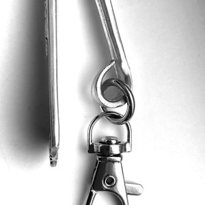 May include: A silver key chain with a swivel clasp and a loop for attaching keys.