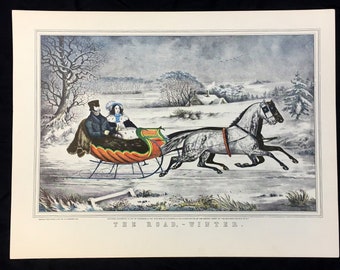 May include: A vintage print of a horse-drawn sleigh with two people inside, traveling through a snowy landscape. The sleigh is red, green, and orange, and the horses are white and gray. The background is a snowy forest with a small house in the distance. The text "THE ROAD. - WINTER." is printed at the bottom of the image.