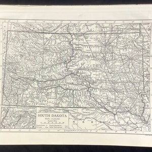 Może przedstawiać: Antyczna czarno-biała mapa Dakoty Południowej, pokazująca granice hrabstw, linie kolejowe i rezerwaty indiańskie. Mapa ma skalę 1:2 700 000 i jest oznaczona jako "South Dakota".