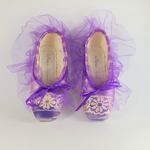 Two Purple Lace Decorated Pointe Shoes