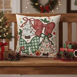 Op de afbeelding: Een vierkant decoratief kussen met een kerstthema. Het kussen heeft afbeeldingen van kerstbomen en strikken in rood, groen en wit. Het kussen ligt op een houten bank met kerstversieringen.