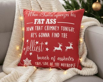 Puede incluir: Cojín navideño decorativo rojo con texto blanco que dice: "Cuando Papá Noel apriete su GRAN CULO por esa chimenea esta noche, va a encontrar al grupo de imbéciles más alegre de este lado del manicomio."