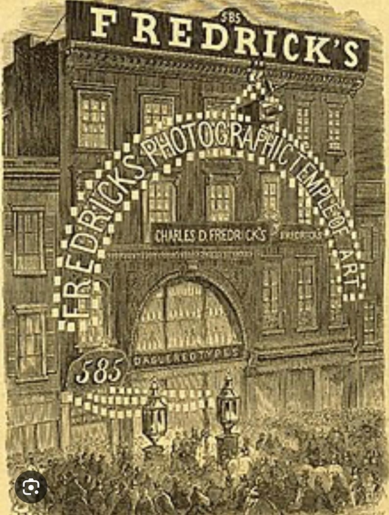 May include: A black and white illustration of a storefront with the text "Fredrick's Photographic Temple of Art" above the entrance. The storefront is located at 585 Broadway and features a large arched window with the text "Daguerreotypes" below it.